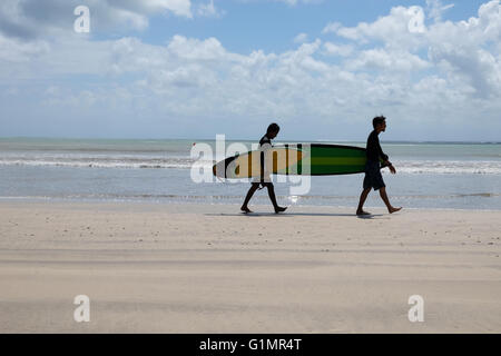 Zwei Surfer zu Fuß am Strand nach dem Surfen. Stockfoto