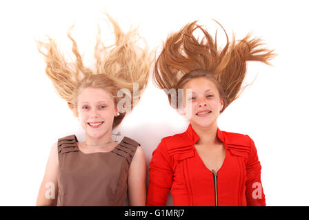 Zwei junge Mädchen mit zerstreuten langen Haaren, isoliert auf weiss Stockfoto