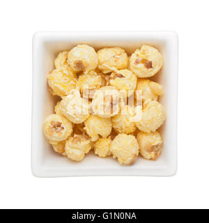 Karamell Popcorn in eine quadratische Schale isoliert auf weißem Hintergrund Stockfoto