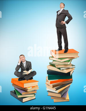 Junger Geschäftsmann auf Stapel Bücher stehen Stockfoto