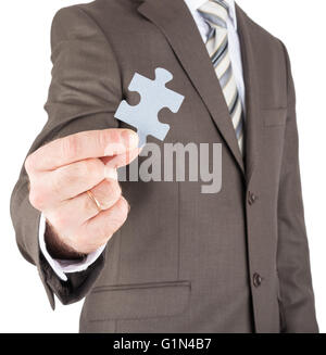 Geschäftsmann hält Puzzleteil Stockfoto
