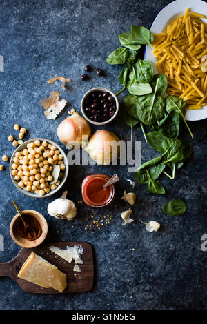 Zutaten für Kichererbsen-Spinat-Nudeln mit Oliven (glutenfreie Quinoa Penne). Stockfoto