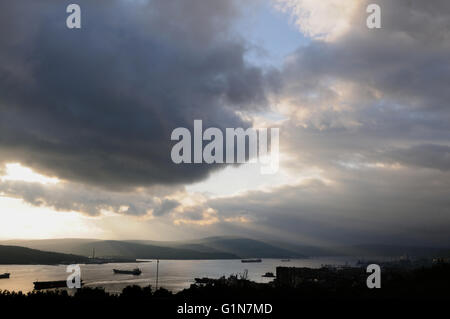 Schwere Himmel Drang durch die Sonnenstrahlen hängen über die Schiffe, die Kola-Bucht, Murmansk, Russland Stockfoto