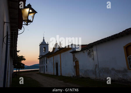 Paraty (oder Parati), ein erhaltenen kolonialen portugiesischen und brasilianischen Reichsstadt liegt an der Costa Verde (grüne Küste), ein üppiger, grüner Korridor, der verläuft entlang der südlichen Küste des Bundesstaates Rio De Janeiro in Brasilien - eines beliebtes Erholungsgebiet für die historischen Bauwerke bekannt und ist bekannt für die Kopfstein gepflasterten Straßen der Altstadt Zentrum. Stockfoto