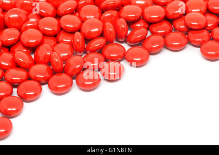 rote Zucker beschichtete Tabletten Tabletten Vitamin auf weißem Hintergrund Stockfoto