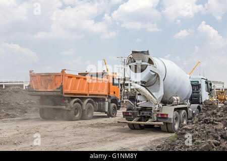 Muldenkipper wird Erde oder Sand auf Baustelle entladen. Stockfoto