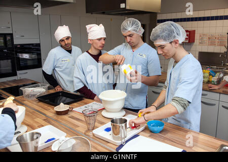 Internationale Schulklasse lernt, wie man kochen und Backen in der Lehrküche. Stockfoto