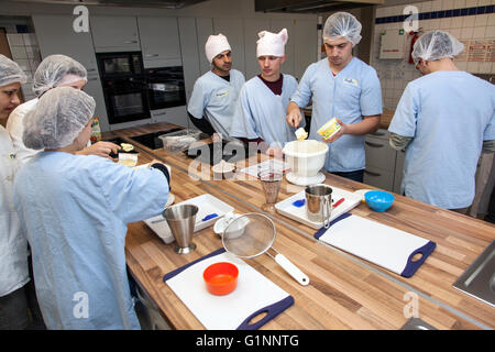 Internationale Schulklasse lernt, wie man kochen und Backen in der Lehrküche. Stockfoto