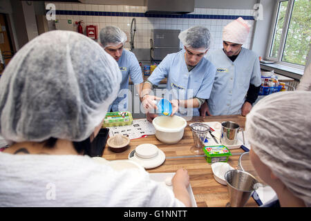 Internationale Schulklasse lernt, wie man kochen und Backen in der Lehrküche. Stockfoto