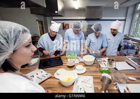 Internationale Schulklasse lernt, wie man kochen und Backen in der Lehrküche. Stockfoto