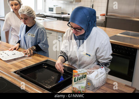 Internationale Schulklasse lernt, wie man kochen und Backen in der Lehrküche. Stockfoto