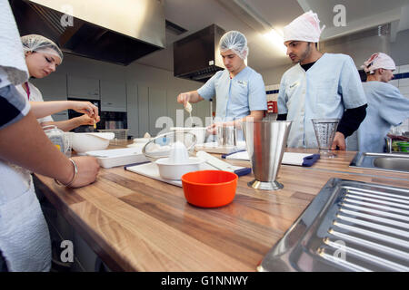 Internationale Schulklasse lernt, wie man kochen und Backen in der Lehrküche. Stockfoto