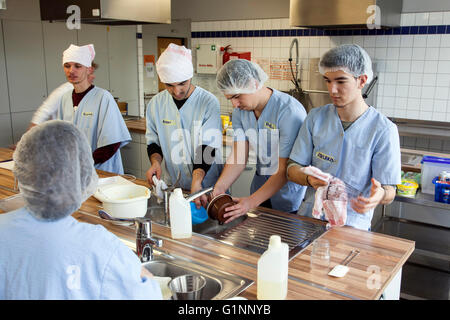 Internationale Schulklasse lernt, wie man kochen und Backen in der Lehrküche. Stockfoto