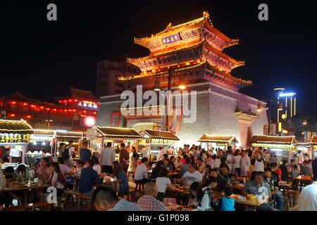 (160518)--KAIFENG, 18. Mai 2016 (Xinhua)--Foto aufgenommen am 17. Mai 2016 zeigt die Szene von einem Nachtmarkt neben einem Trommelturm in Kaifeng, Henan Provinz Zentral-China. Kaifeng hat eine lange Geschichte von seiner berühmten Nachtmarkt, wo eine Vielzahl von Spezialitäten wie fünf-Gewürz-Brot, dampfenden Pie und Knödel sind auf den Verkauf. Am Abend verwandeln Kaifeng Straßen in Restaurants während Hunderte von Anbietern ihre Stände öffnen und Verkauf von Lebensmitteln für Menschen aus den nahe gelegenen Städten, da die Atmosphäre sehr ansprechend. Kaifeng ist historisch bekannt als Daljan, Dongjing Bianliang, Bianjing Stockfoto