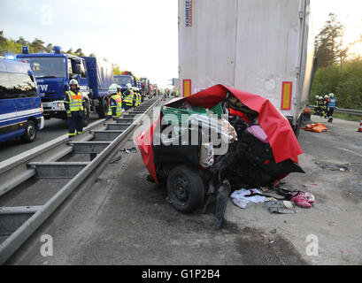 Ein Auto ist mit einer Plane zwischen zwei LKW nach einem Unfall auf der Autobahn A6 in der Nähe von Nürnberg, 17. Mai 2016 bedeckt. Bei dem Unfall am Dienstag wurden mindestens vier Menschen getötet. Foto: Daniel Karmann/dpa Stockfoto