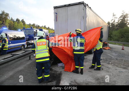 Rettungskräfte decken ein Auto mit einer Plane nach einem Unfall auf der Autobahn A6 in der Nähe von Nürnberg, 17. Mai 2016. Bei dem Unfall am Dienstag wurden mindestens vier Menschen getötet. Foto: Daniel Karmann/dpa Stockfoto