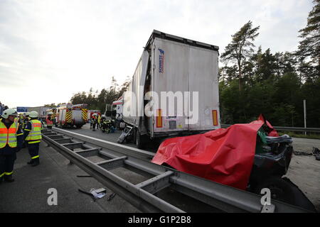 Ein Auto ist nach einem Unfall auf der Autobahn A6 in der Nähe von Nürnberg, 17. Mai 2016 mit einer Plane bedeckt. Bei dem Unfall am Dienstag wurden mindestens vier Menschen getötet. Foto: Daniel Karmann/dpa Stockfoto