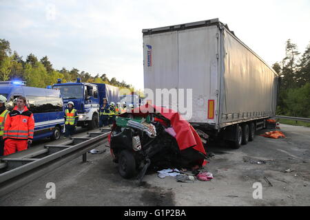Ein Auto ist mit einer Plane zwischen zwei LKW nach einem Unfall auf der Autobahn A6 in der Nähe von Nürnberg, 17. Mai 2016 bedeckt. Bei dem Unfall am Dienstag wurden mindestens vier Menschen getötet. Foto: Daniel Karmann/dpa Stockfoto