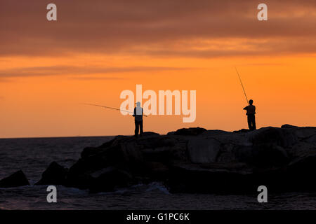 Silhouette der Männer Angeln auf der Mole von Balboa Island, Newport Beach bei Sonnenuntergang in Südkalifornien Stockfoto