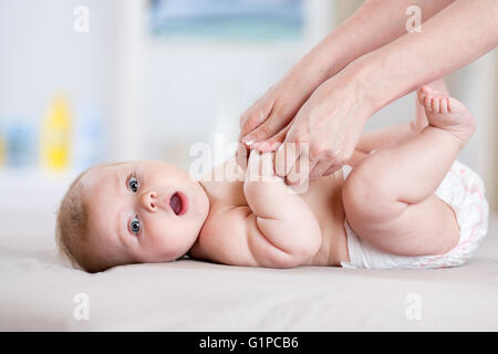 Mutter ihr Babymädchen massieren Stockfoto