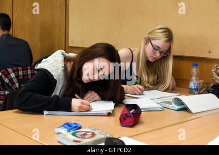 Schüler im Klassenzimmer während einer Schreibaufgabe. Stockfoto