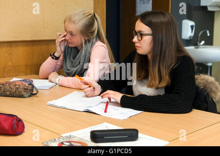 Schüler im Klassenzimmer während einer Schreibaufgabe. Stockfoto