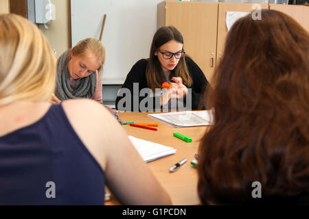 Schüler im Klassenzimmer während einer Schreibaufgabe. Stockfoto