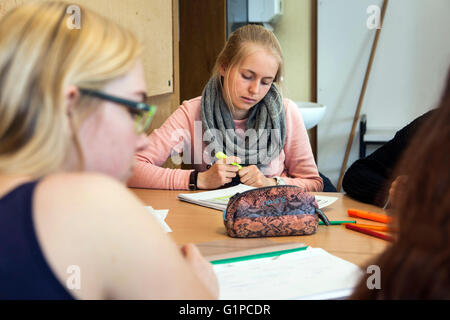 Schüler im Klassenzimmer während einer Schreibaufgabe. Stockfoto