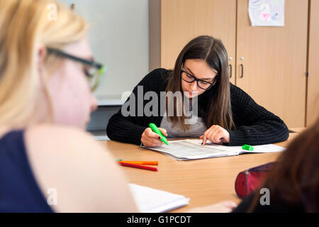 Schüler im Klassenzimmer während einer Schreibaufgabe. Stockfoto