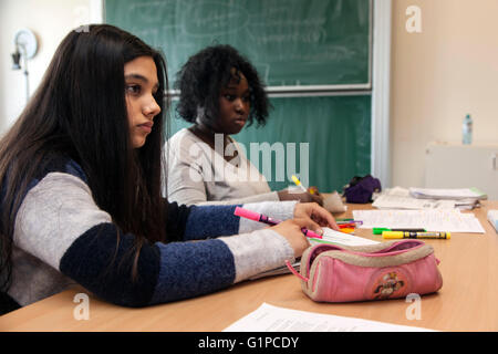 Schüler im Klassenzimmer während einer Schreibaufgabe. Stockfoto