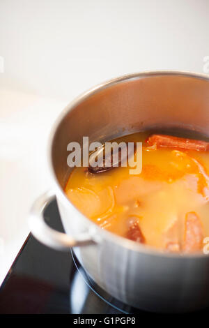 große Silber Metall-Pfanne mit typisch spanisches Essen Eintopf mit Bohnen aus Asturien Blutwurst Wurst auf schwarzen Herd in whi Stockfoto