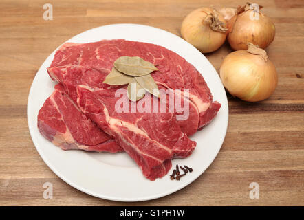 Rindfleisch auf einem Teller mit ein paar Zwiebeln und Gewürzen Stockfoto