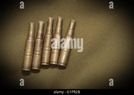 Patronenhülsen auf Textil mit Sepia-Effekt und Vignettierung. Stockfoto