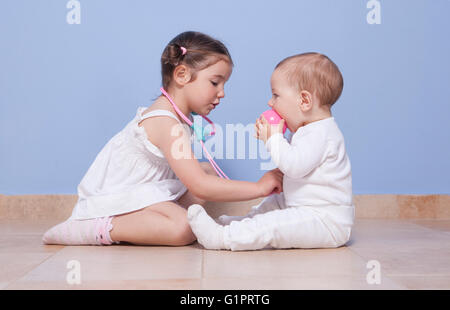Babyschwester Bruder und Kleinkind spielen Arzt mit Stethoskop Stockfoto