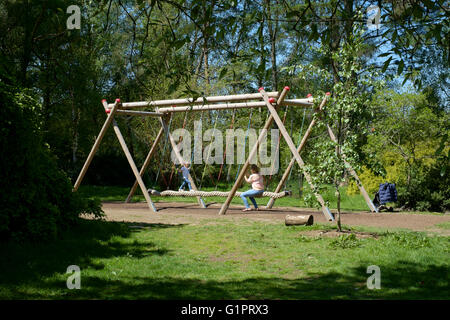 Mutter und Tochter auf einem Seil schwingen in Sir Harold hügeliger Gärten in Romsey England uk Stockfoto