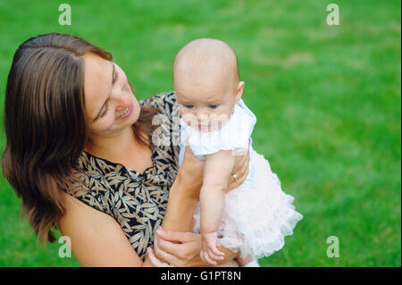 junge Mutter-Holding-Tochter in die Arme Stockfoto