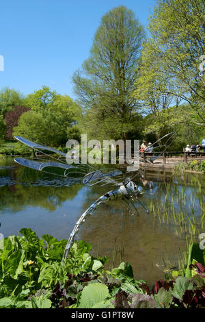 Libelle-Skulptur mit Blick auf einen Teich in Sir Harold hügeliger Gärten in Romsey England uk Stockfoto