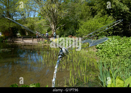 Libelle-Skulptur mit Blick auf einen Teich in Sir Harold hügeliger Gärten in Romsey England uk Stockfoto