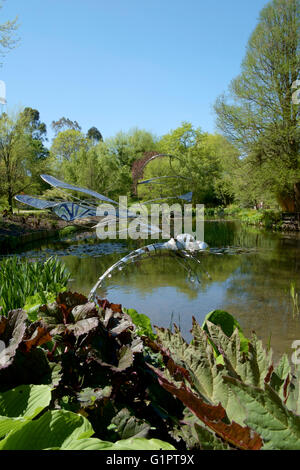 Libelle-Skulptur mit Blick auf einen Teich in Sir Harold hügeliger Gärten in Romsey England uk Stockfoto