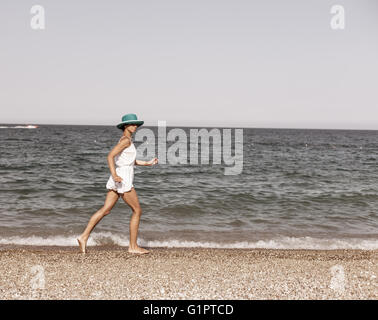 Frau am Strand laufen. Vintage-Stil. Stockfoto