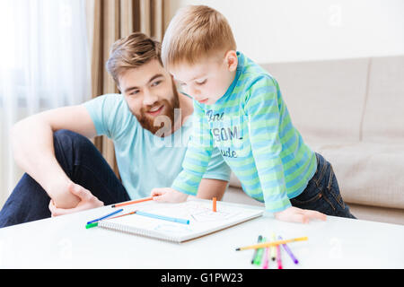 Happy little Boy und sein Vater zu Hause zusammen zeichnen Stockfoto