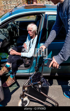 Eine ältere behinderte Frau, die immer aus einem Auto, Brighton, Sussex, UK Stockfoto