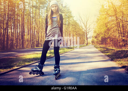 Teenager-Mädchen auf Rollschuhen im Sommer. Inline-Skates sport Konzeptbild. Vintage Retro-Farben-Bild. Stockfoto