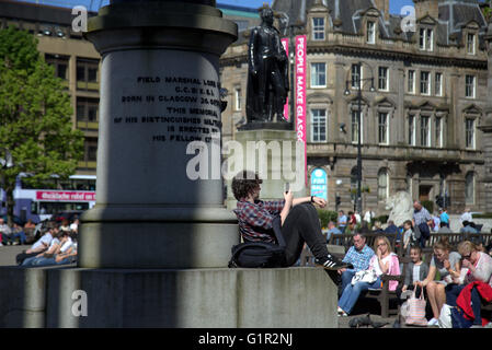 Sonniger Tag mit jungen am Telefon George Square, Glasgow, Scotland, UK. Stockfoto