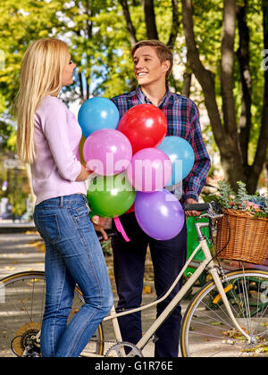 Paar mit Luftballons auf Retro-Rad im Park. Stockfoto