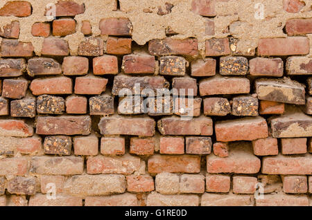 Unregelmäßig geformte verwitterten roten Stein Mauer. Stockfoto