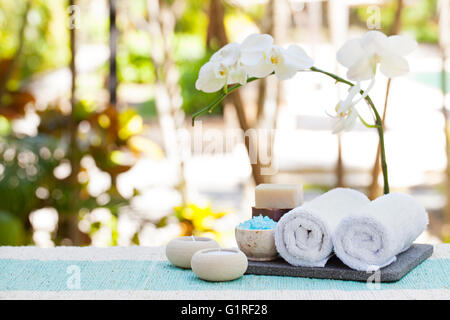 Spa und Wellness massage Einstellung Stillleben mit Kerze, Handtuch und Steinen Outdoor-Sommer-Hintergrund Stockfoto