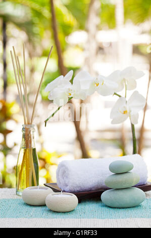 Spa und Wellness massage Einstellung Stillleben mit Kerze, Handtuch und Steinen Outdoor-Sommer-Hintergrund Stockfoto