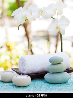 Spa und Wellness massage Einstellung Stillleben mit Kerze, Handtuch und Steinen Outdoor-Sommer-Hintergrund Stockfoto