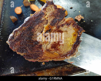 Gebratene Black Angus Entrecote Steak auf einem Spatel, infront von einem Braten Tisch Stockfoto